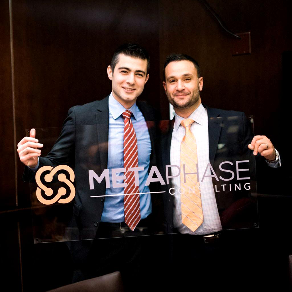 Fred Costa and Brett McLaren holding an early MetaPhase sign