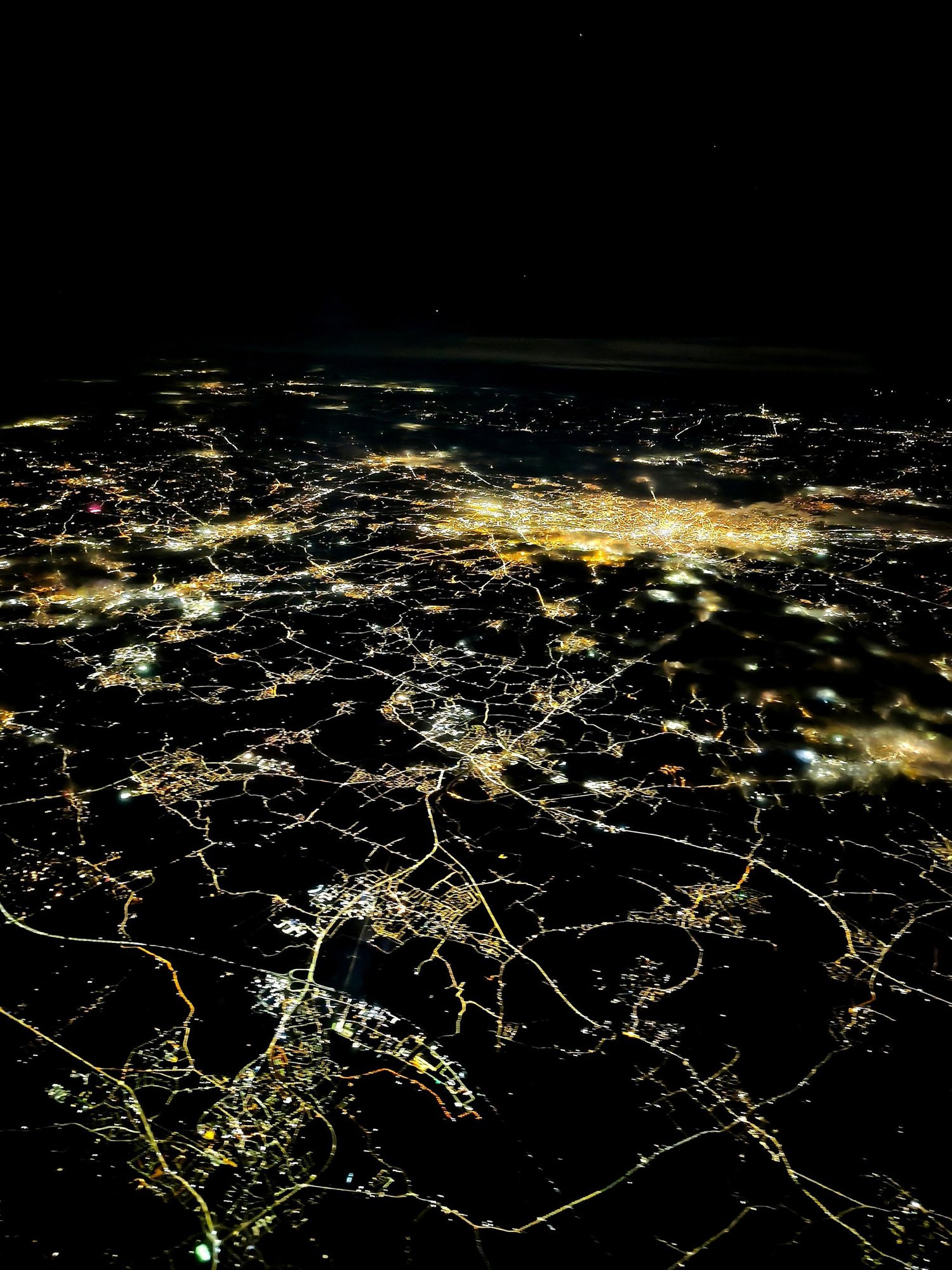 Aerial view of illuminated roads and communities at night