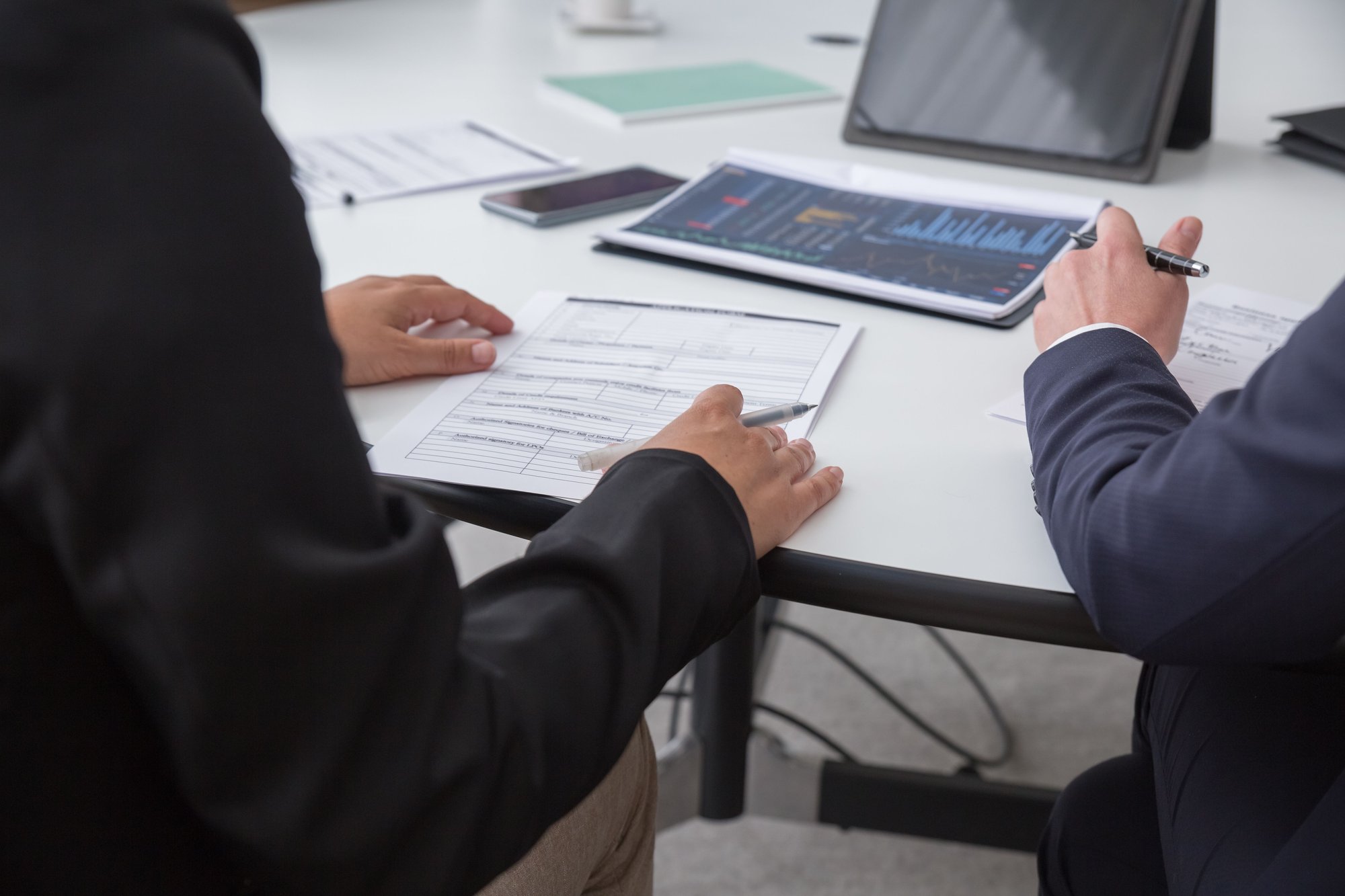 Business professionals reviewing forms and performance information